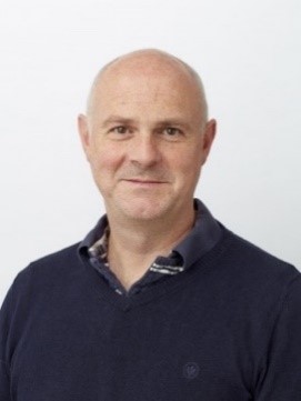 Head and shoulders image of Professor Gareth Jenkins in front of a light-coloured background wearing a dark coloured shirt. 