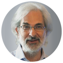 Prof Alan Boobis. Alan has grey hair, half rimmed glasses and grey facial hair. Alan is wearing a light coloured shirt and is photographed in front of a light coloured background. 